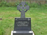 WB12 - Honed Dark Grey Headstone with a Celtic Design Cross Top and Two Bird Designs.